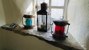 três lanternas sentadas numa saliência ao lado de uma janela em Donore - Quintessential English Cottage close to Dittisham Quay em Dittisham