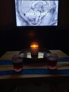 three candles on a table with a tv in the background at Apartament Sunrise in Mikołajki