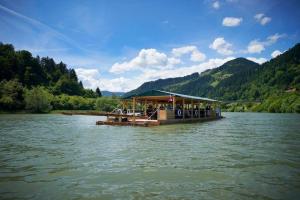 un barco en un río con gente en él en Apartment Rozika, en Slovenj Gradec