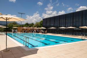 a large swimming pool with people standing near a building at Apartment Rozika in Slovenj Gradec