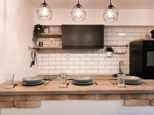 a kitchen with a wooden table with plates and glasses at Apartment Sleep & Fly Zagreb Airport in Velika Gorica
