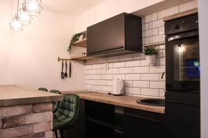 a kitchen with black cabinets and a counter top at Apartment Sleep & Fly Zagreb Airport in Velika Gorica