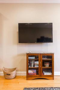 a flat screen tv on a wall with a book shelf at The Wrigleyville VIP-200 Steps from Wrigley Field in Chicago