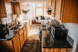 uma cozinha com um lavatório e um fogão forno superior em The Longhorn Cabin - Cabins at Rim Rock em Austin
