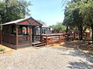 a wooden gazebo with a fence around it at The Longhorn Cabin - Cabins at Rim Rock in Austin