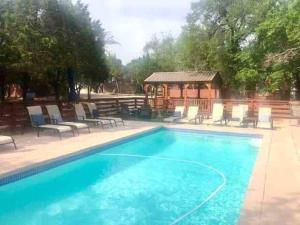 una piscina con sillas y un cenador en The Longhorn Cabin - Cabins at Rim Rock, en Austin