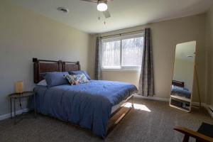 Schlafzimmer mit einem Bett, einem Fenster und einem Spiegel in der Unterkunft Pocono Lake Retreat - Relaxing 3bdm retreat w/ High Speed Wi-Fi, Work Space and Firepit in Pocono Lake