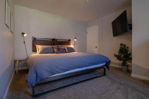 een slaapkamer met een groot bed en een televisie bij Pocono Lake Retreat - Relaxing 3bdm retreat w/ High Speed Wi-Fi, Work Space and Firepit in Pocono Lake