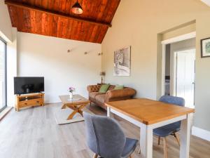 a living room with a table and a couch at Swallow Cottage in Sandbach