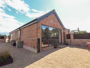 un edificio de ladrillo con una gran ventana de cristal en Swallow Cottage, en Sandbach