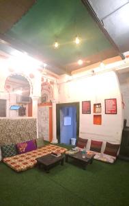 salon z kanapą i dwoma stołami w obiekcie Yogg Hostel w mieście Waranasi