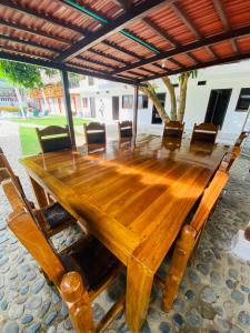 a wooden table with chairs and a large wooden table at Hotel Randuky Tayrona in El Zaino
