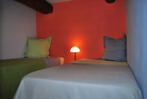 - 2 lits dans une chambre dotée d'un mur rouge dans l'établissement Bed and Breakfast Jardin de Marie, à Aix-en-Provence