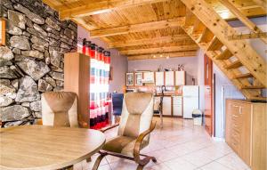 Una habitación con una mesa y sillas y una pared de piedra. en 2 Bedroom Amazing Home In Lubiatowo, en Lubiatowo