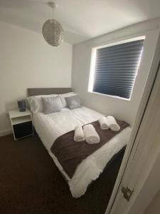 a bedroom with a bed with two towels on it at Spacious 1 Bedroom Apartment with free parking in Wednesbury