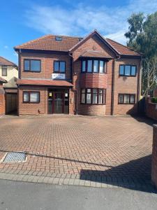 a brick house with a brick driveway in front of it at Spacious 1 Bedroom Apartment with free parking in Wednesbury