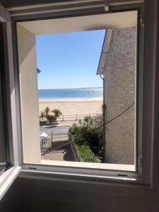 uma janela com vista para a praia em Appartement Chez Bernadette à 50m de la plage em Saint-Cast-le-Guildo