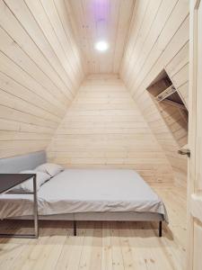 Ce lit se trouve dans un dortoir doté d'un plafond en bois. dans l'établissement 3kampai, à Moletai