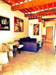 een woonkamer met een bank en een tafel bij La Dormeuse in Lucignano