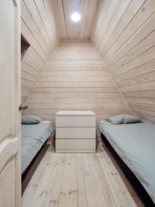 - une chambre avec 2 lits dans une pièce en bois dans l'établissement 3kampai, à Moletai