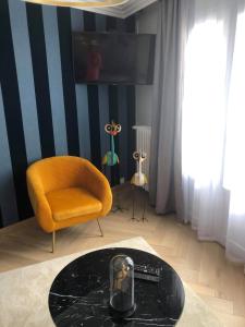 uma sala de estar com uma cadeira amarela e uma mesa em Appartement Chez Bernadette à 50m de la plage em Saint-Cast-le-Guildo