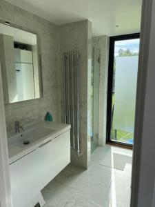 a bathroom with a sink and a mirror and a window at Stylish lake view house in Vadstena