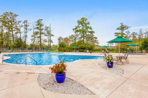una piscina con 2 jarrones azules con flores en Villas of Bethany West -- 722C Treetop, en Bethany Beach