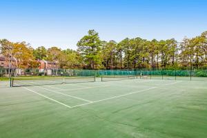 una pista de tenis con dos raquetas de tenis. en Villas of Bethany West -- 722C Treetop, en Bethany Beach