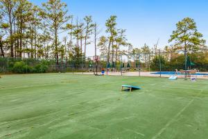 una pista de tenis verde con un banco azul en Villas of Bethany West -- 722C Treetop, en Bethany Beach