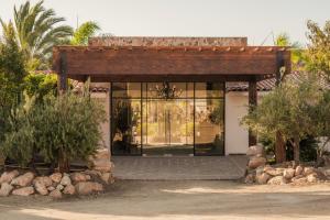 a house with glass doors and trees and bushes at Surya Hotel in Valle de Guadalupe