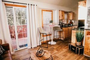 a living room with a table and a kitchen at The Bison Cabin - The Cabins at Rim Rock in Austin