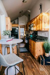 una cocina con armarios de madera y una mesa con sillas. en The Bison Cabin - The Cabins at Rim Rock, en Austin