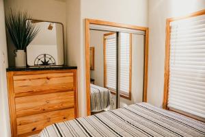 a bedroom with a bed and a dresser and a mirror at The Bison Cabin - The Cabins at Rim Rock in Austin