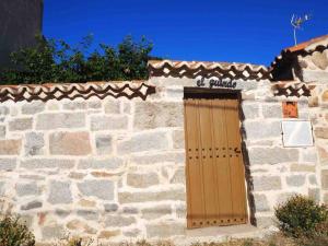 ein Steingebäude mit einer Holztür darauf in der Unterkunft Casa Rural El Guindo in Avila