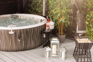 a hot tub on a deck with a table and a chair at Home From Home Northampton in Northampton