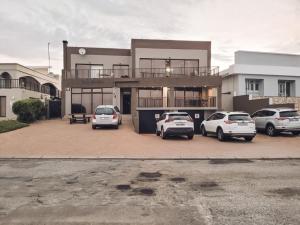 three cars parked in a parking lot in front of a building at See-Struis in Stilbaai