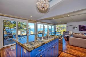 eine Küche mit einem Waschbecken und ein Wohnzimmer in der Unterkunft Entire Private Coastal Retreat - Spectacular Ocean Views wHot Tub in Montara