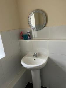 a bathroom with a white sink and a mirror at Lovely 2 bedroom Flat at Palm Court in Bournemouth,5 minutes away from beach, whole flat is yours for the time you stayed in Bournemouth