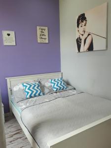 uma cama num quarto com duas fotografias na parede em Apartament Twoja Przystań em Giżycko