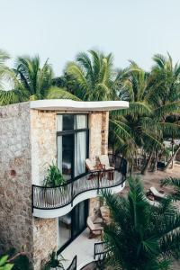 a house with a balcony with chairs and palm trees at Cucu Hotel El Cuyo in El Cuyo +77 photos