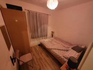 a small bedroom with a bed and a window at Studenac Mionica 