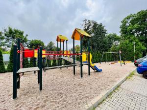 a playground with a play equipment in the sand at Apartament Eva 2 in Jelenia Góra