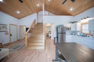 uma cozinha com uma escada e uma cozinha com armários brancos em Light And Bright Cabin Close To Pates Ford Marina em Smithville