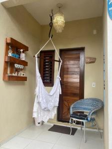 um quarto com uma cadeira e uma camisa pendurada numa parede em Pousada Paracuru Surf em Paracuru
