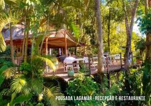 un complejo con terraza en el bosque en Pousada Lagamar, en Praia Vermelha