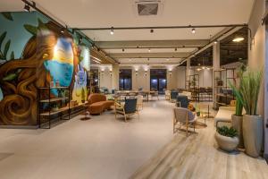 a large lobby with chairs and tables and a mural at Slaviero Hotel Ponta Grossa in Ponta Grossa