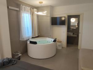 a bathroom with a tub in the middle of a room at Live Home Rooms in Villasimius +67 photos