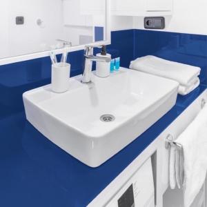 a white sink in a bathroom with blue walls at Blue Side Orbi City in Batumi +36 photos