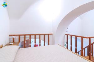 um quarto com uma cama branca e uma escada em Casamare em Amalfi