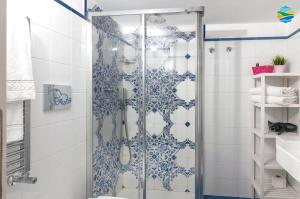 uma casa de banho com um chuveiro com azulejos azuis e brancos em Casamare em Amalfi